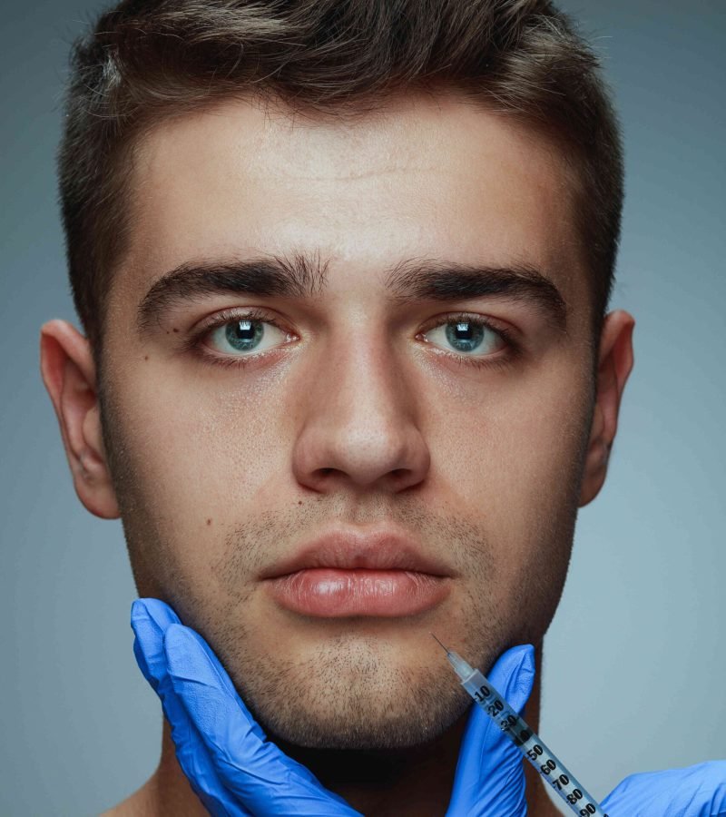 close-up-portrait-young-man-isolated-grey-studio-background-filling-surgery-procedure-concept-men-s-health-beauty-cosmetology-self-care-body-skin-care-anti-aging_optimized close-up-portrait-young-man-isolated-grey-studio-background-filling-surgery-procedure-concept-men-s-health-beauty-cosmetology-self-care-body-skin-care-anti-aging_optimized